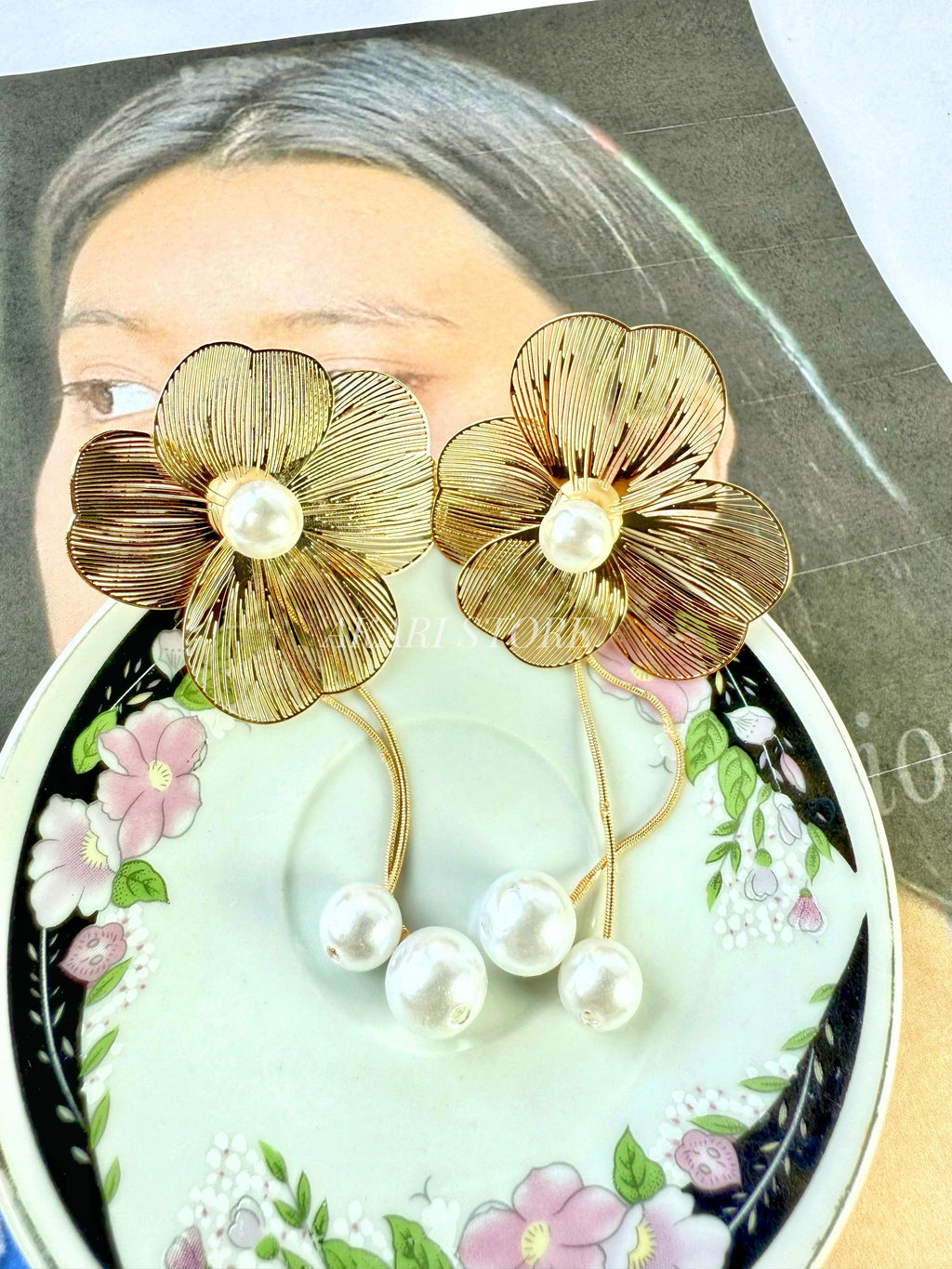 Aretes dorados con flecos de flor y perlas