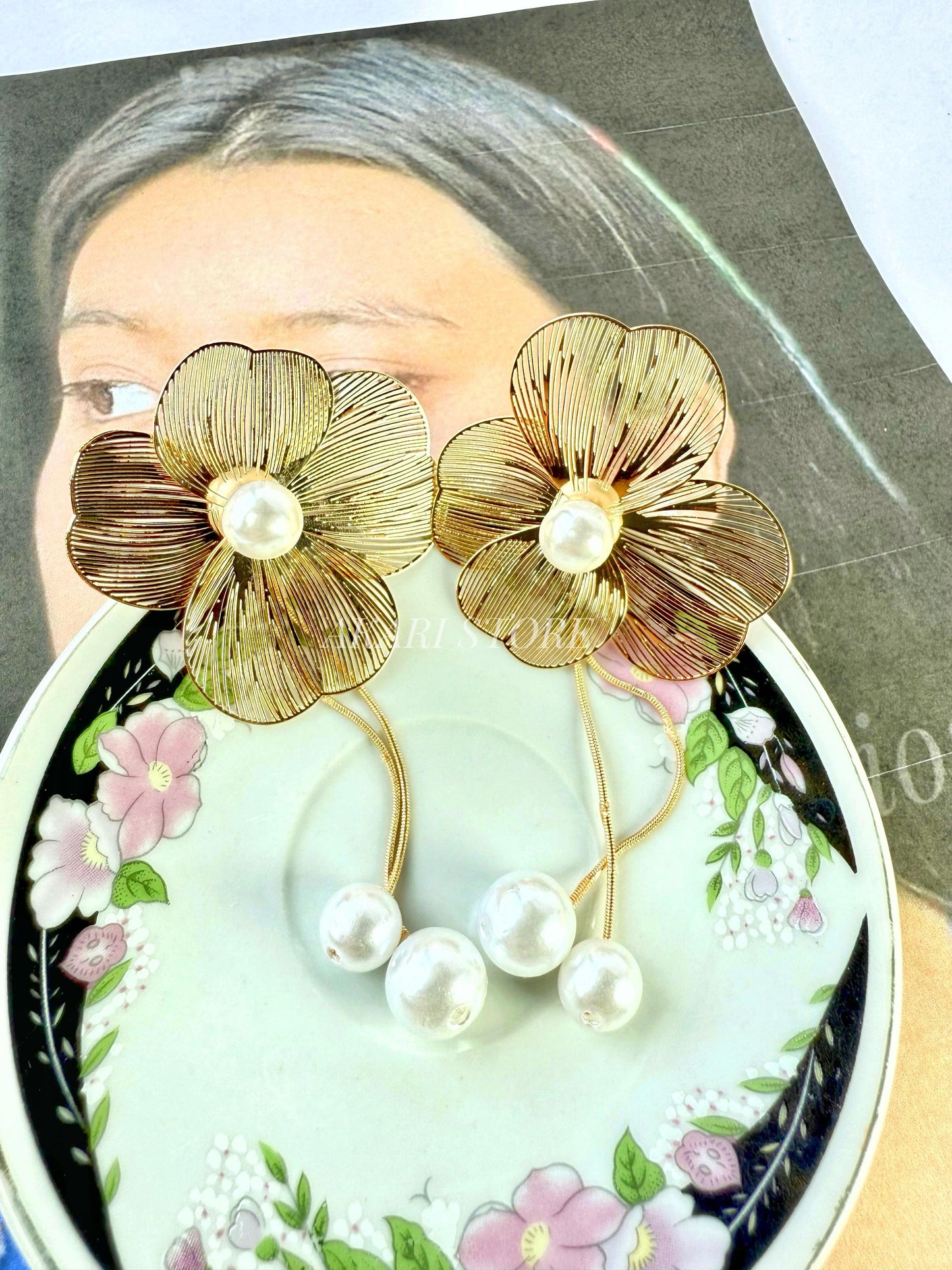 Aretes dorados con flecos de flor y perlas