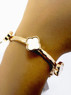 Brazalete dorado con dijes de trébol blanco