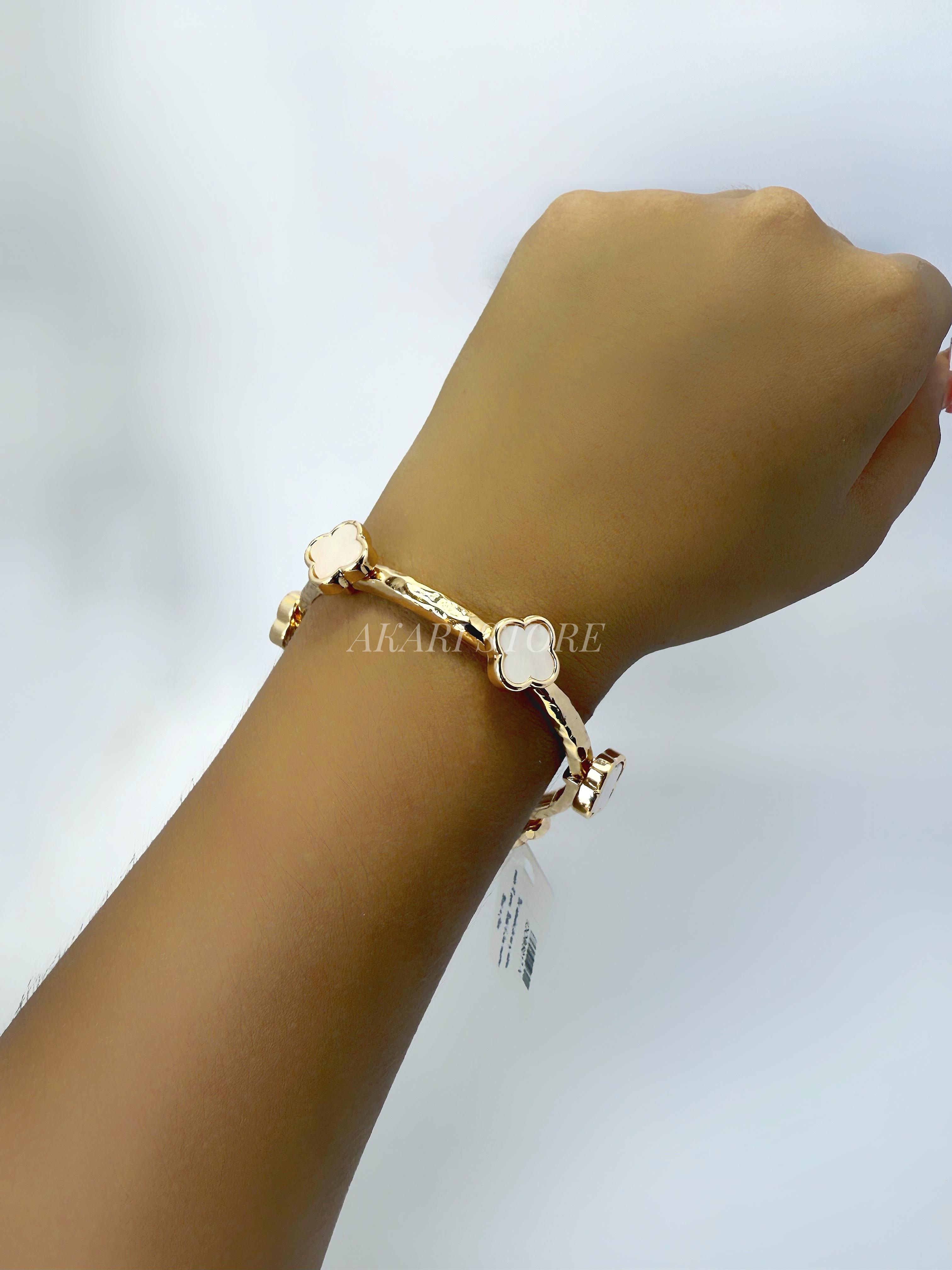 Brazalete dorado con dijes de trébol blanco