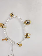 Pulsera  de perlas blancas con dijes dorados