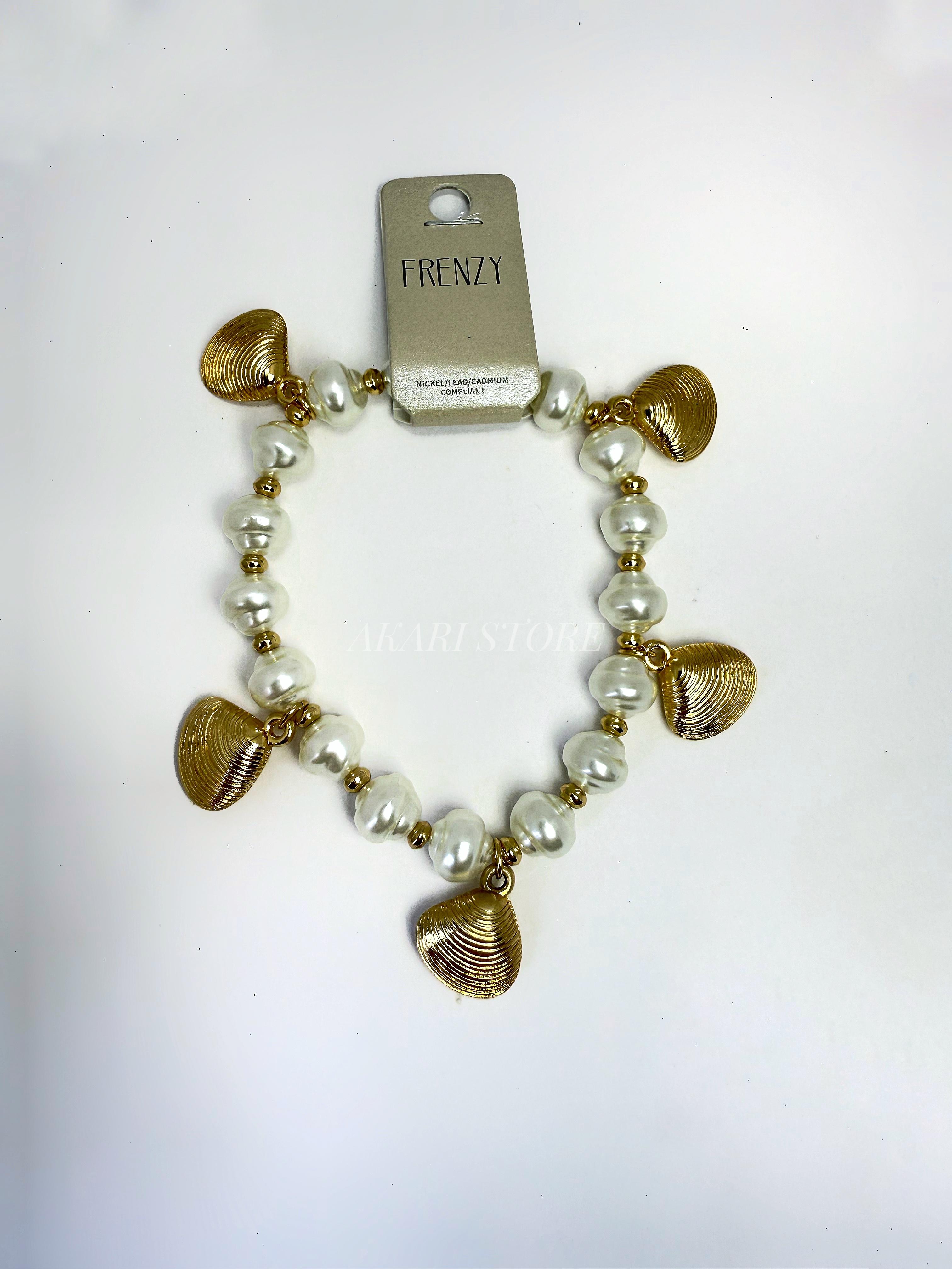 Pulsera dorada con dijes de conchas y perlas