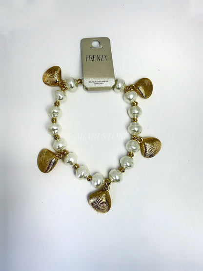 Pulsera dorada con dijes de conchas y perlas