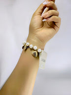 Pulsera dorada con dijes de conchas y perlas