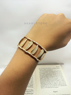 Brazalete con pluma y cuencas metálicas