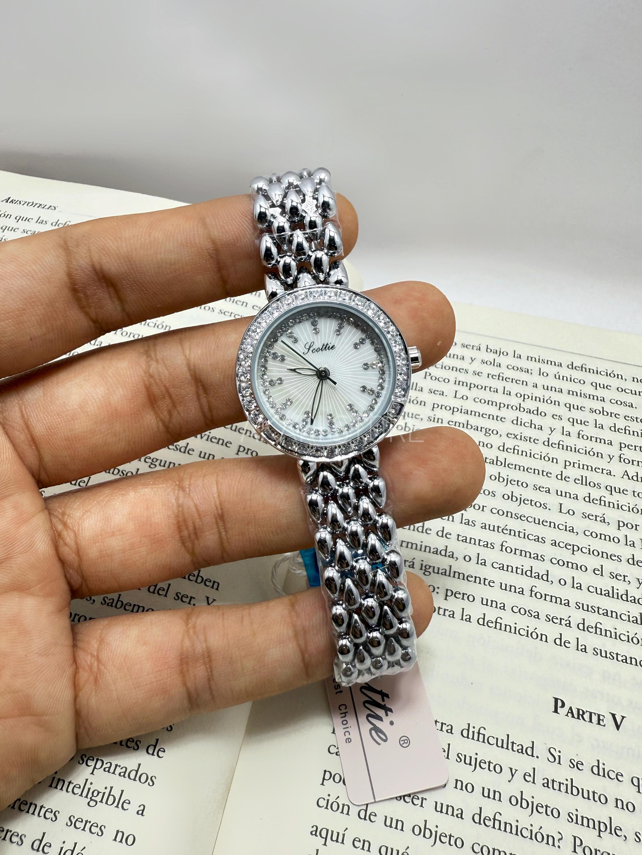 Reloj circular plateado con brillos