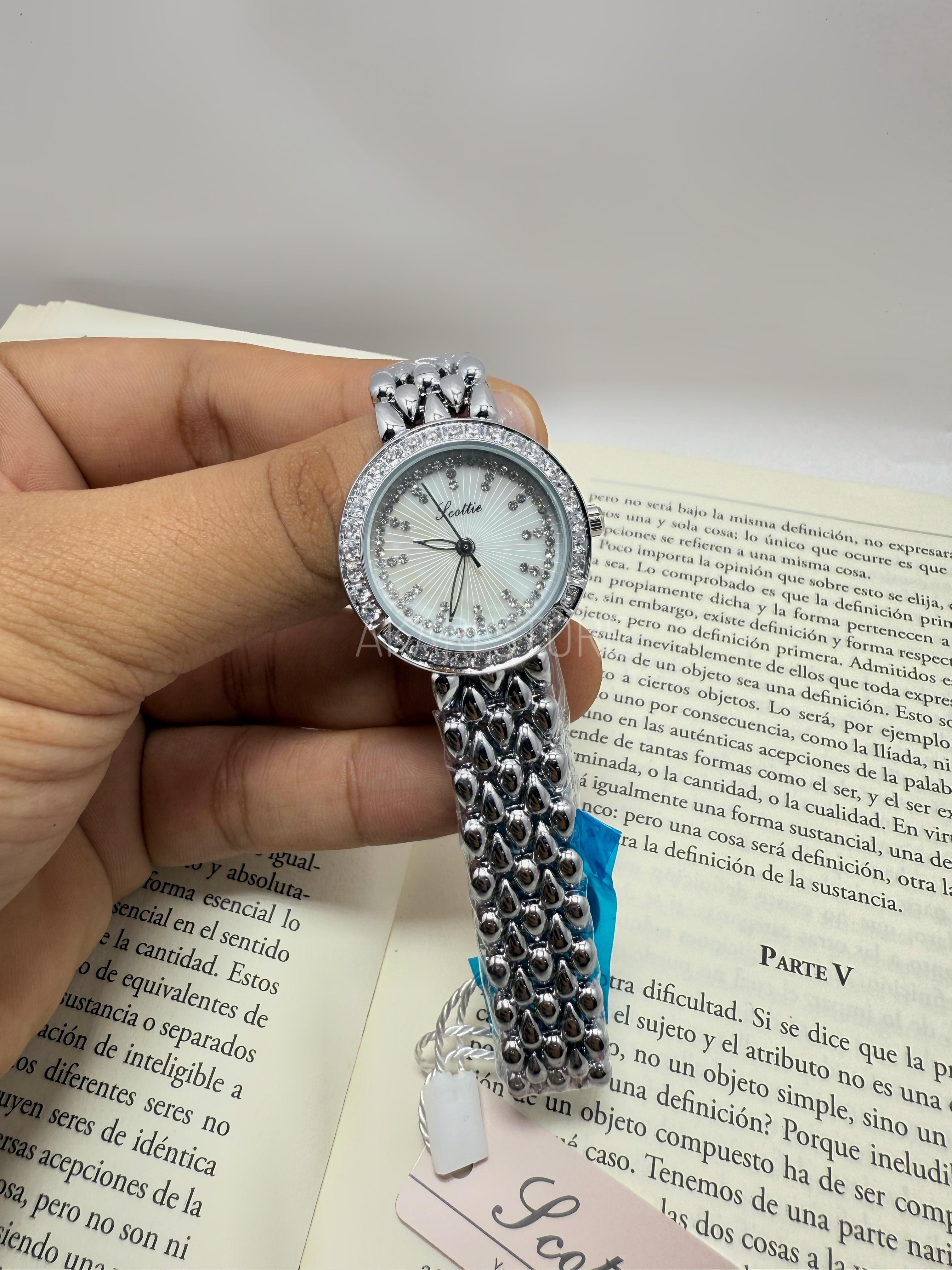 Reloj circular plateado con brillos