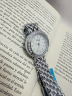 Reloj circular plateado con brillos