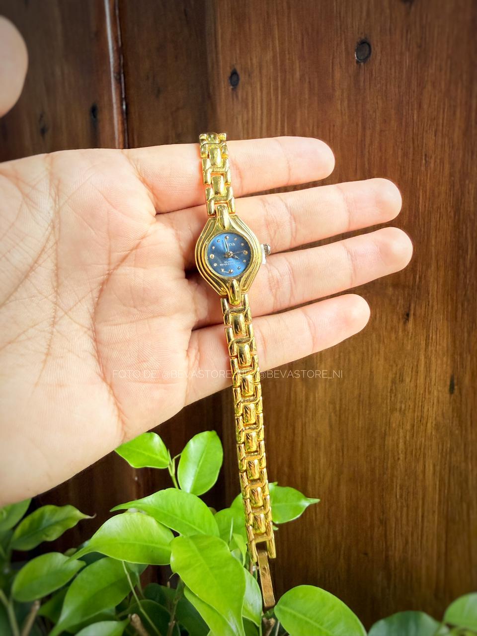 Reloj dorado con fondo de color